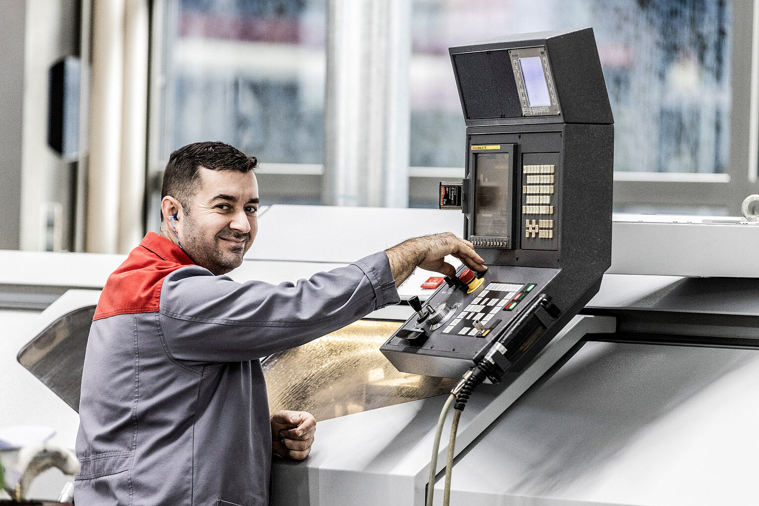 Weiss Präzisionstechnik Stanzwerkzeuge Ein Mann mit Gehörschutz bedient eine Maschine